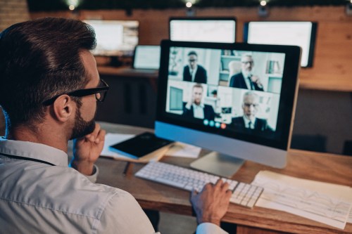 Confident,Young,Man,Having,Video,Conference,With,The,Colleagues,While