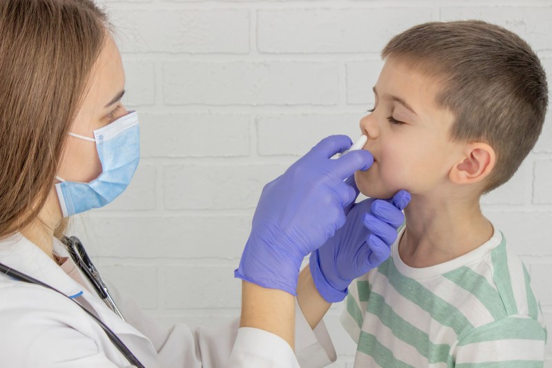 Female doctor drips drops into nose. Pediatrician's appointment, healthcare concept